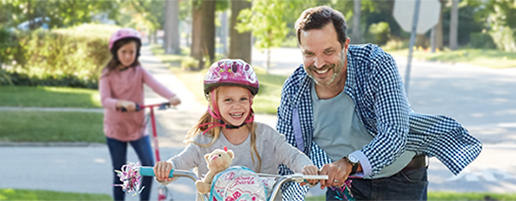 Father teaching child how to ride bike